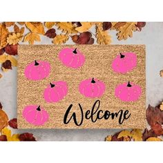 a welcome mat with pink pumpkins on it