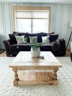 a living room with a couch, coffee table and large window in it's center