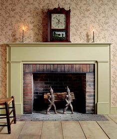 two statues are sitting in front of a fireplace