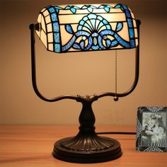 a stained glass lamp on top of a table next to a picture frame and photo