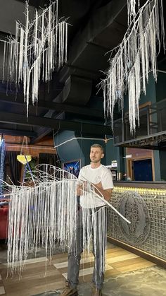 a man standing in front of an ice sculpture with icicles hanging from the ceiling