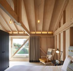 a bedroom with wood paneling and white bedding