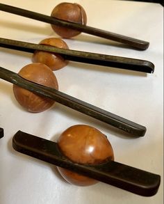 four pieces of wood are arranged on top of some chopsticks and one has an egg in the middle