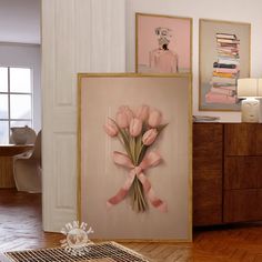 there is a painting on the wall with pink flowers in front of it and other artwork