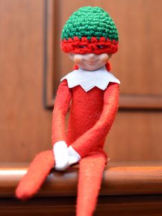 an elf doll sitting on top of a wooden table