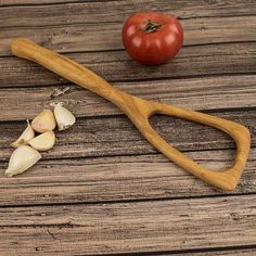 a wooden cutting board with garlic and tomato on it, next to a pair of scissors