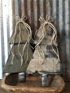 two wooden christmas trees sitting on top of a wooden sled