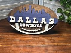 a wooden sign with the word cowboys on it and a football in front of a building