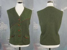 This stunning green vest has a delicate medallion tweed pattern on the upper-right front, lower-left front, and on the full back. The other part of the front is a fine boucle texture. The 1990s German vintage vest has two faux flap pockets on the front, and closes with four faux polished walnut seed buttons. The vest is lined in a green satin polyester fabric. Bust = 40 inches (101.6cm) Waist = 39 inches (99.06cm) Hips = 43 inches (109.22cm) Vest Length = 24 inches (60.96cm) Brand label: Meico L Classic Green Vest For Winter, Classic Green Winter Vest, Green Winter Vest With Buttons, Green Buttoned Vest For Workwear, Vintage Green Vest For Fall, Green Vintage Vest For Fall, Tweed Pattern, Green Vest, Vintage Vest