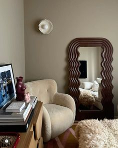 a living room filled with furniture and a large mirror on the wall above it's headboard