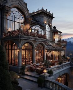 an elaborately designed house with lots of windows and balconies on the roof