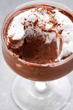 a chocolate dessert in a glass with whipped cream on top