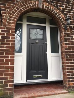 a black and white front door on a brick building