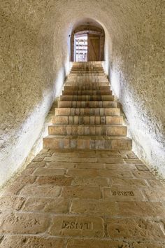 the stairs are made of stone and lead up to an open door on one side