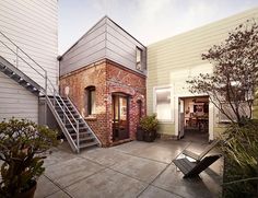 a brick building with stairs leading up to the front door and entry way, in an urban setting