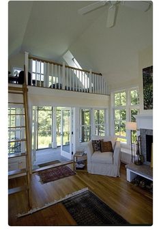 a living room filled with furniture and a fire place in front of a staircase leading up to a second story