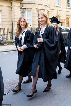 some people in graduation gowns are walking down the street