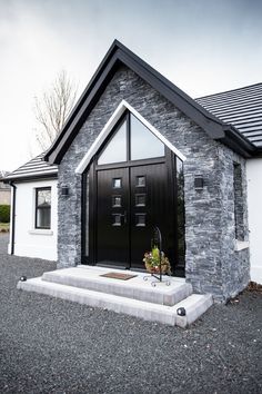 a black and white house with a plant in the front