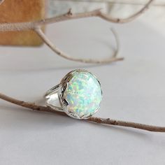 Large silver ring, handcrafted decorated leaves all around set with a delicate lab-grown Opal gemstone, look like a big crown. Gorgeous and full of presence, highlight any outfit you wear. Lab-grown opals usually display a very distinctive snakeskin pattern and they show brighter colors than natural opals. The spots of color are larger but they interact with light in a very similar way to natural opals. Top size: 1.8 inches Stone size: 20mm. Size to order: 5-16 U.S Match necklace: https://www.et Unique Silver Jewelry, White Opal Ring, Ring Opal, Round Rings, Engagement Anniversary, Ring Unique, Opal Ring, Opal Pendants, Simple Jewelry