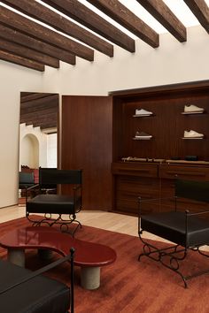 a living room filled with lots of furniture and wooden beams on the ceiling above it