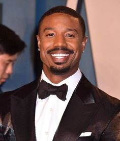 a man in a tuxedo smiles at the camera