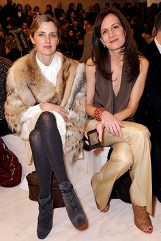 two women sitting next to each other at a fashion show