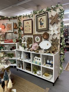 a room filled with lots of furniture and pictures hanging on the wall above it's shelves