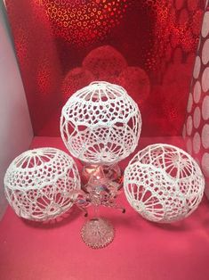 three white vases sitting next to each other on a pink surface