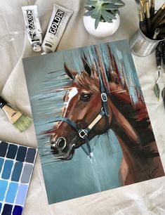 a painting of a brown horse next to some paint brushes and watercolors on a white sheet