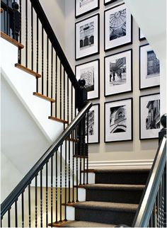 a staircase with pictures on the wall and carpeted stairs leading up to the second floor