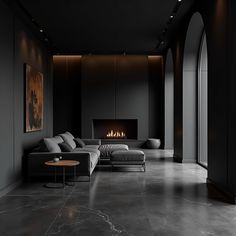 a modern living room with black walls and flooring is lit by the fire place