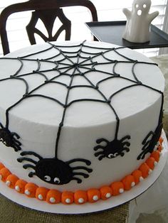 a spider web cake is decorated with orange and black icing