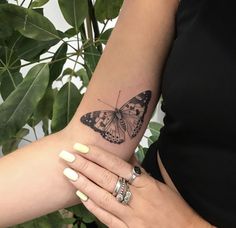 a woman's arm with a butterfly tattoo on the left side of her wrist