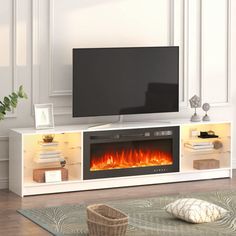 an entertainment center with a television and fire in the fireplace, next to a couch