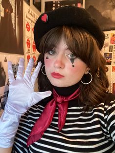 a woman wearing white gloves and a black hat with hearts painted on her face is posing for the camera