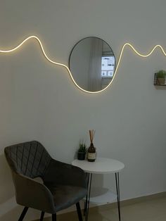 a chair and table in a room with two mirrors on the wall, one has a potted plant next to it