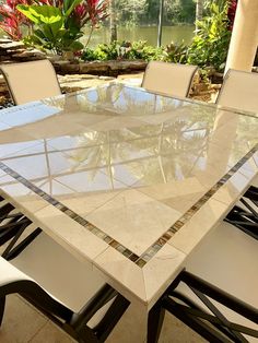 a glass table with white chairs around it