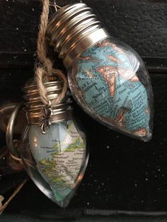 two heart shaped bottles are hanging from a string on a doorknob with a map in it