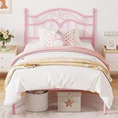 a pink bed with white sheets and pillows on top of it next to a dresser