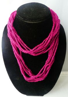 a black mannequin holding a pink necklace on it's neck and the words travese bay crochet