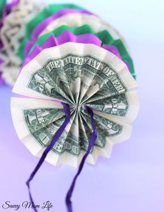 dollar bill origami fan on purple and green ribbon