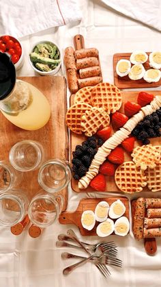 a table topped with waffles, fruit and other foods