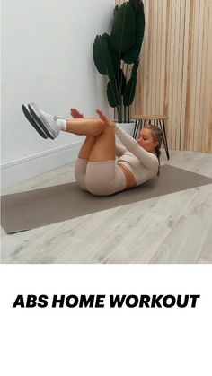 a woman laying on the floor with her legs crossed and arms behind her head, doing an abs home workout