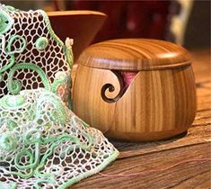 a wooden box sitting on top of a table next to a bowl and net bag