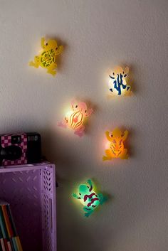 some little lights that are on the wall above a book shelf in a child's room