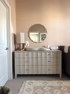 a bathroom with a dresser, mirror and rug