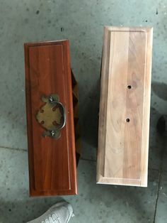 two pieces of wood sitting on the ground next to each other with holes in them