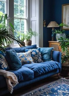 a living room with blue couches and potted plants