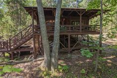 a cabin in the woods with stairs leading up to it's second floor and second story