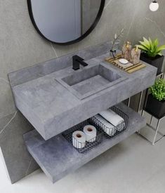 a bathroom sink sitting under a mirror next to a counter with two rolls of toilet paper on it